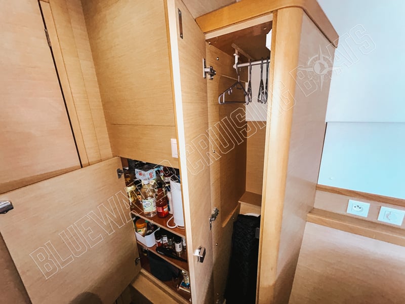 Well-organized guest stateroom storage in a used 2018 Lagoon 42-2, featuring a spacious wardrobe with shelves and hanging space.