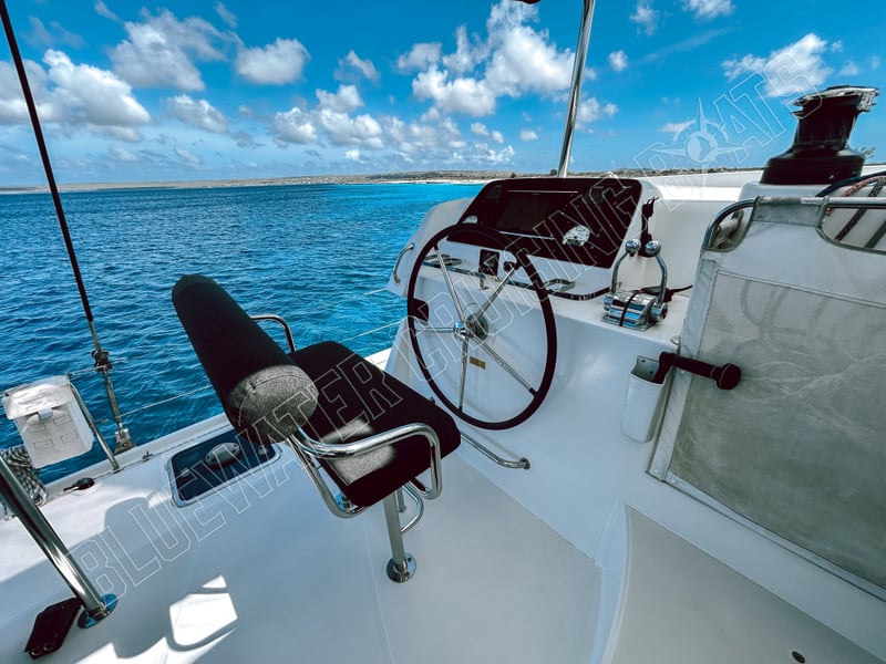 Well-equipped helm station of a 2018 Lagoon 42-2 boat featuring a comfortable captain's chair and sleek controls, overlooking tranquil waters.