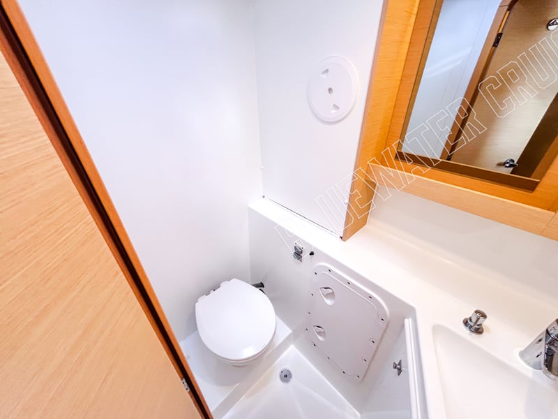 Compact guest head in a 2018 Lagoon 42-2 with modern fixtures, white fiberglass surfaces, and efficient layout.